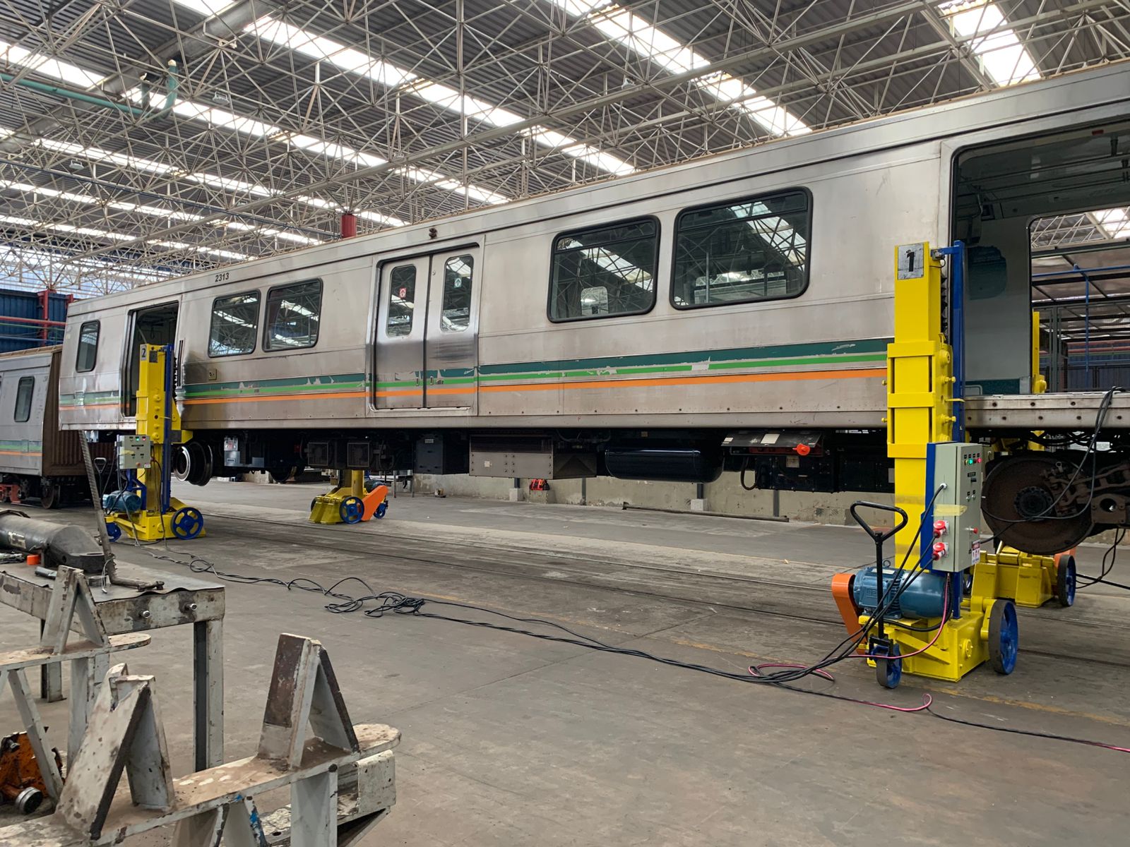 Macacos de elevação içando um carro de trem inteiro