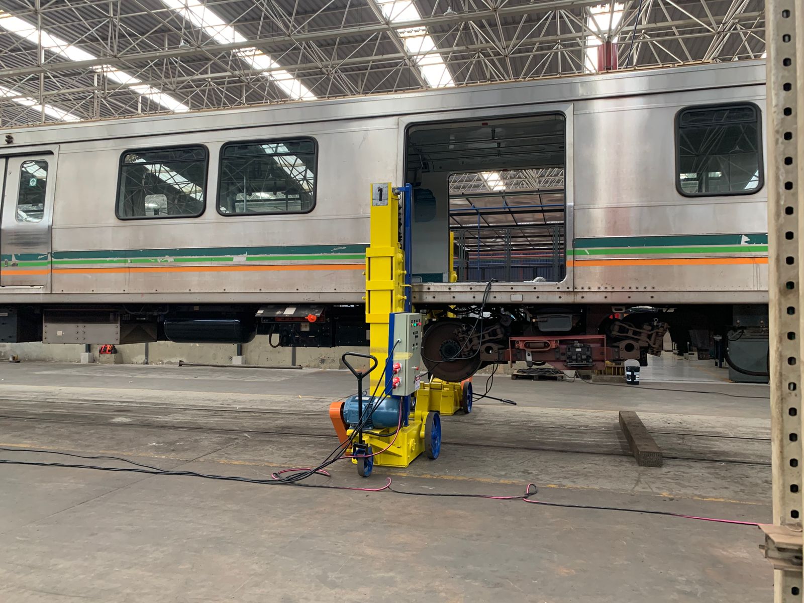 Macaco de elevação posicionado sob carro ferroviário